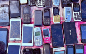 collection of phones from various eras, in various states of disrepair, displayed side by side